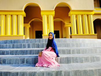 Woman smiling while sitting on staircase