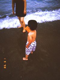 Rear view of friends on shore at beach