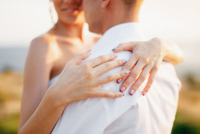 Midsection of couple holding hands