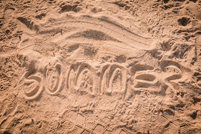 High angle view of text on sand