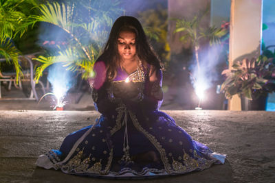 Portrait of woman sitting at night