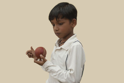 Boy holding apple against white background