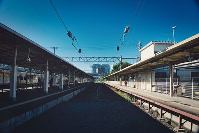 View of railroad station platform against clear blue sky