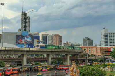 Bridge and buildings in city against sky