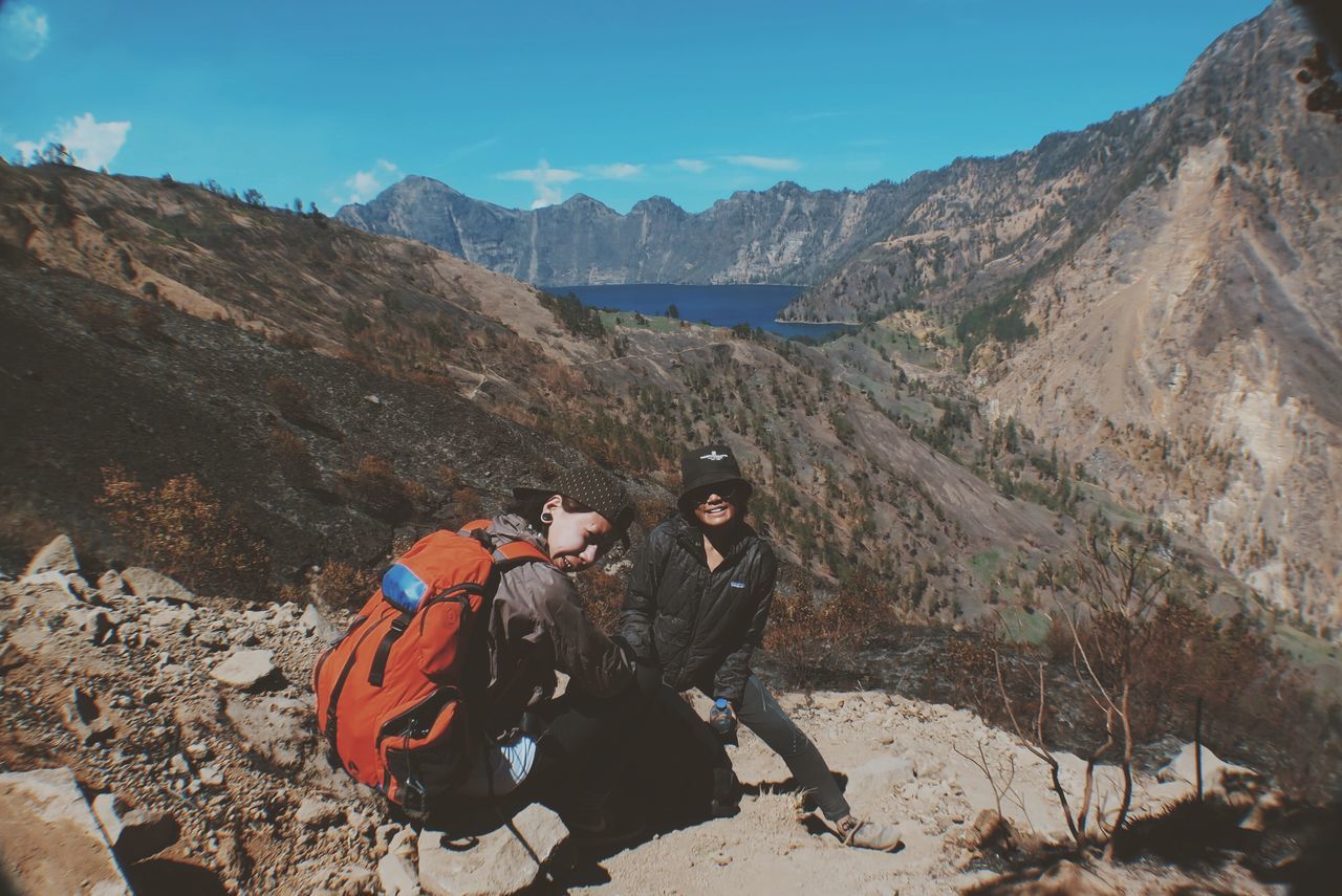 mountain, mountain range, leisure activity, tranquility, landscape, beauty in nature, nature, adventure, scenics, lifestyles, tranquil scene, rock - object, non-urban scene, men, sky, sunlight, full length, rock formation