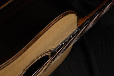 High angle view of acoustic guitar on bed