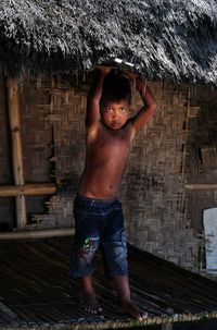 Portrait of shirtless boy standing outdoors