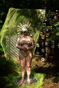 A woman in a reflective mask against the background of a cd/dvd case scenery in the forest