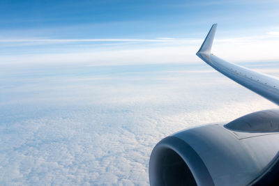 Airplane wing over cloudscape