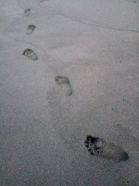 High angle view of footprints on sand at beach