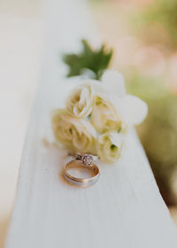 Close-up of wedding rings on white flower