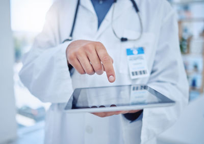 Midsection of doctor holding dentures