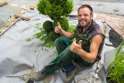 High angle portrait of smiling man gardening in lawn