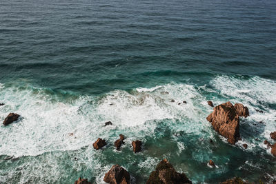 High angle view of rocks on sea shore