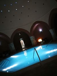 Low angle view of illuminated lights hanging from ceiling in building