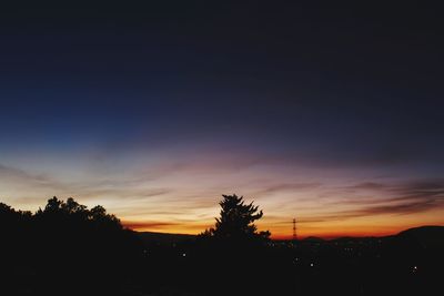 Silhouette trees against sky at sunset