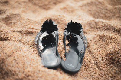 High angle view of slippers on sand at beach