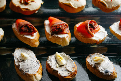 A close up of a bunch of appetizers on a glass stand. crostini with salmon fillet.