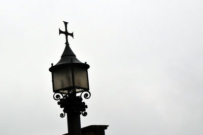 Low angle view of weather vane against clear sky