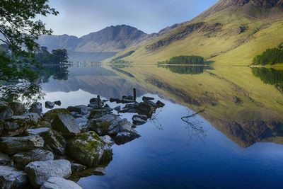 Scenic reflection of green landscape in calm lake