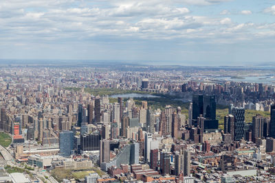 Aerial view of cityscape against cloudy sky