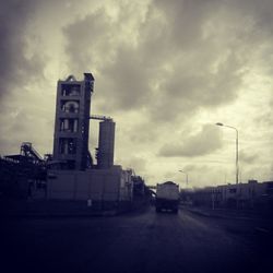 Cars on road against cloudy sky