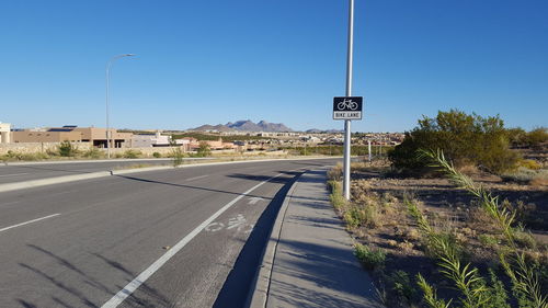 View of road sign against clear blue sky