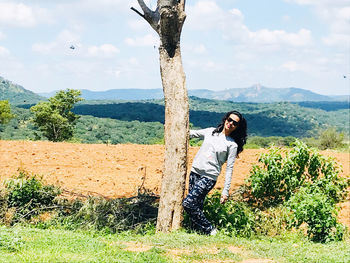 Woman standing on field against sky