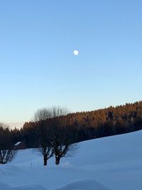 Scenic view of snow covered land against clear blue sky