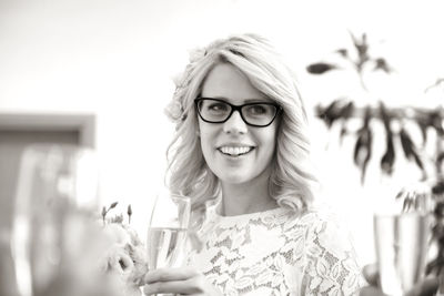 Portrait of young woman wearing eyeglasses against sky