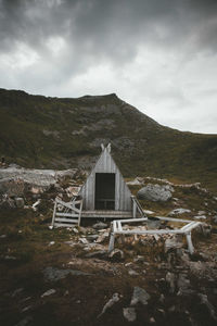 View of shack on land against sky