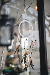 Close-up of dream catcher hanging by window