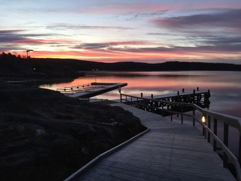 Pier over sea against sky during sunset