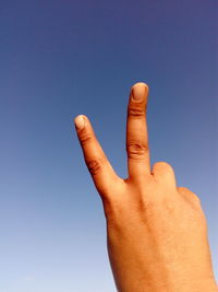 Human hand forming victory sign