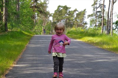 Full length portrait of girl standing on road