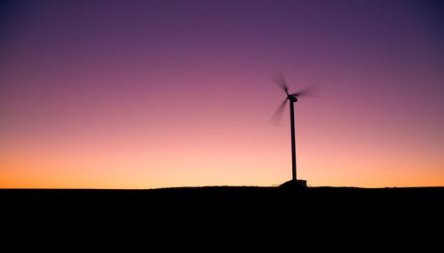 Wind turbines on field at sunset