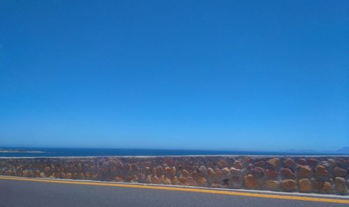 Scenic view of beach against clear blue sky