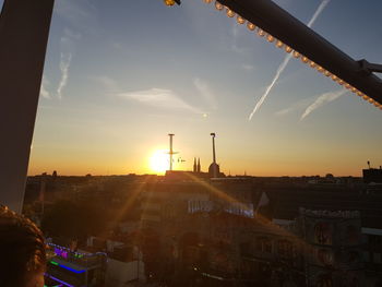 Buildings in city against sky during sunset