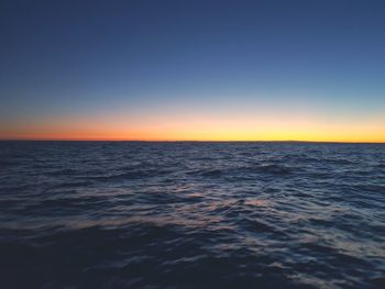 Scenic view of sea against clear sky at sunset