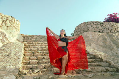 Low angle view of woman standing on rock formations