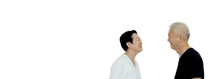 Side view of two people against white background