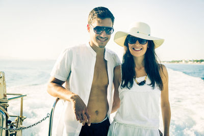 Portrait of smiling young couple standing on beach