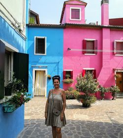 Portrait of woman standing against building