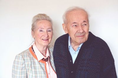 Senior couple standing against wall