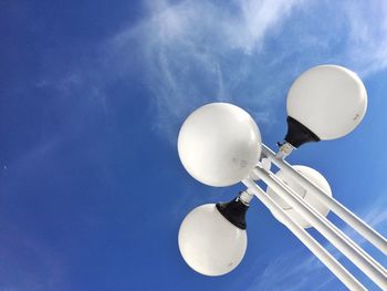 Low angle view of lighting equipment against blue sky