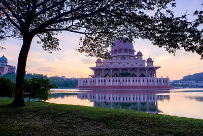 Building by lake during sunset