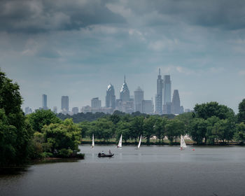 Buildings by river against sky