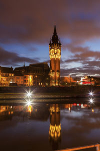 Illuminated buildings in water at night