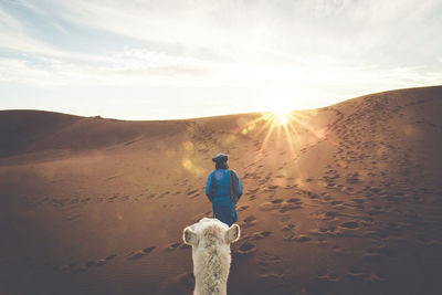 Rear view of a man standing against the sky