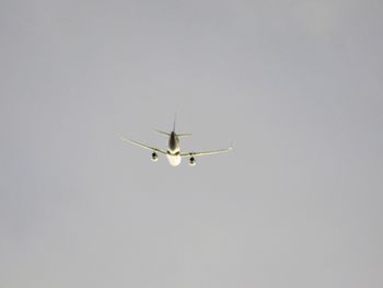 Low angle view of airplane flying against clear sky